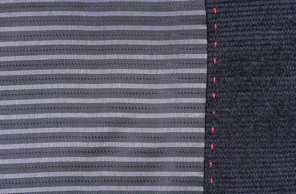 Close up of an exposed coptic stitch binding on a custom notebook, showing the intricate structural thread work
