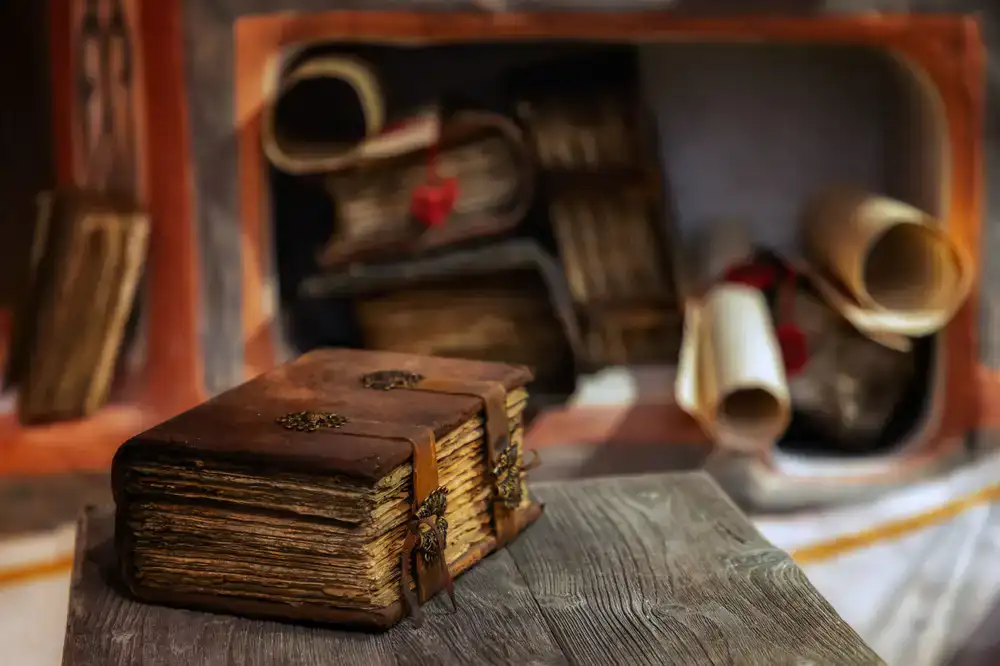 A craftsman's desk with bookbinding tools, thread, and half-bound leather covers