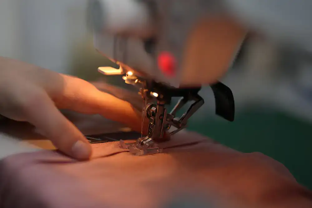 Close up of a craftsperson sewing the spine of a book with thick linen thread