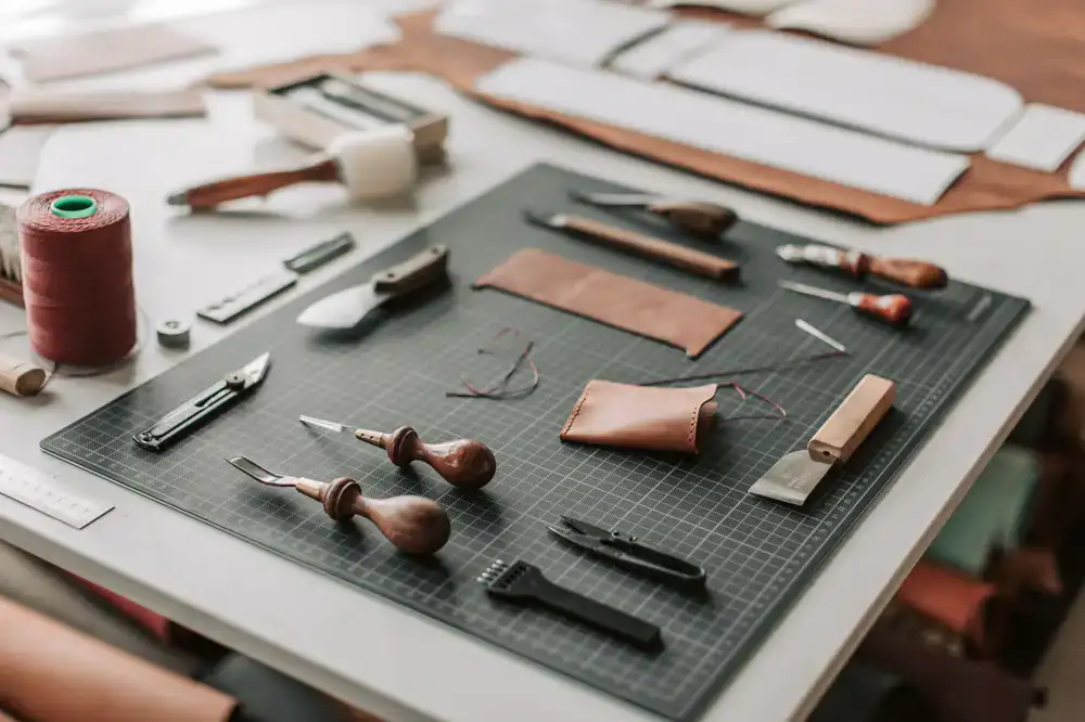 A workbench prepared for a class with bone folders, awls, and cutting mats